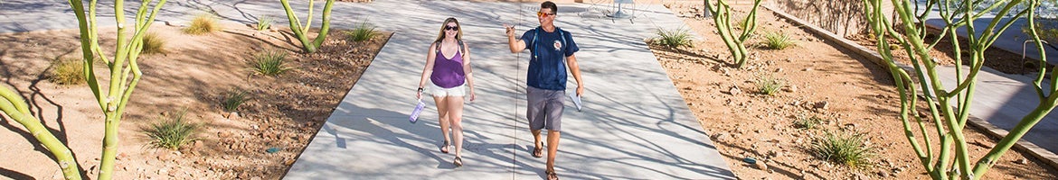 Two students walking along path on campus