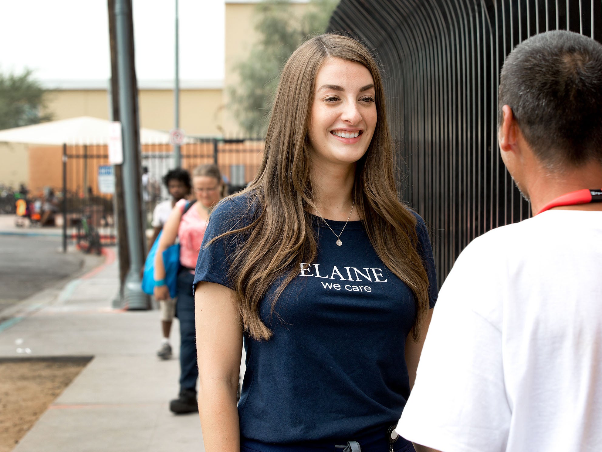 A woman speaking to a man outdoors