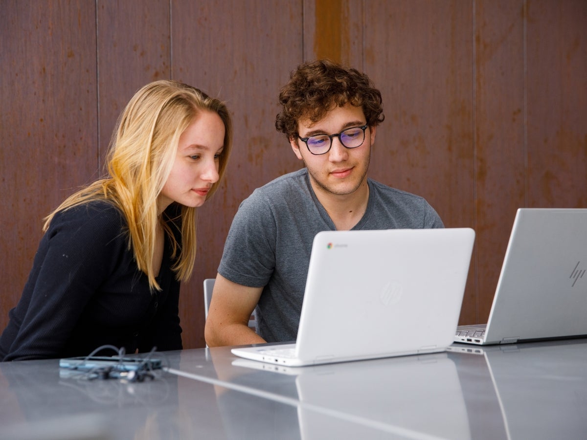 two students working on a computer